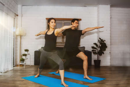 Asian couples doing home exercises for good health and warm family relationships show each other love and happiness at home.の写真素材