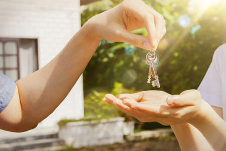 New Home concept : Handing Over the Key handed the two house keys to the female owner of the new home in front of her houseの写真素材
