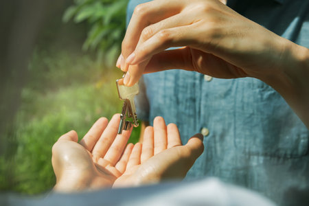 Close-up Top view husband hands the keys to the wife who loves to enjoy their new home : Happiness of the family moving into a new home : Selective Focusの写真素材