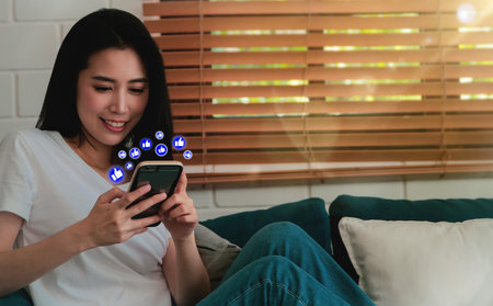 Like is happy : Asian women relax happy home with smartphones, social communication, commenting, messages and delightful things to find on modern social mediaの写真素材