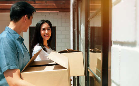 Young couples planning their families, moving into a new home,family happiness and living together : Asian couple brings home accessories boxes to the door of their family's new home with happy smileの写真素材