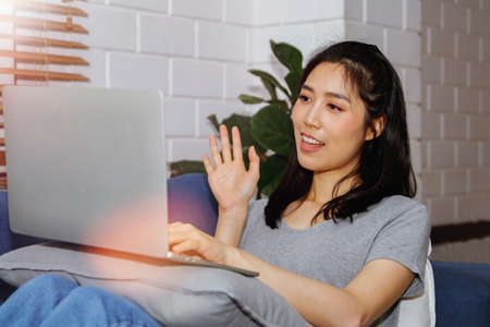 Concept of a new normal life : Video calls between Asian women greeting their lovers through cameras, laptops, computers with happiness, love for lovers, women in long distance relationships together.の写真素材