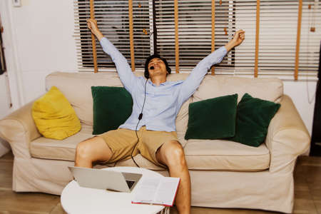 Businessmen sit on the sofa, work from home, are easy to put on, rest, stretch out and relax after a video conference Freelance career in personal business, he is most delighted : Selective Focusの写真素材