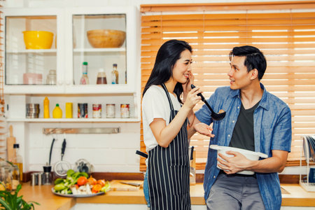 Couples have fun cooking in the kitchen : Delicious soup made by housewives, sweet and romantic new family breakfast.の写真素材