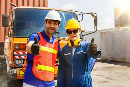 The caucasian engineers and Asian workers driving the cargo truck partners work together in great friendship in Container place for export business logistics and import exportの写真素材