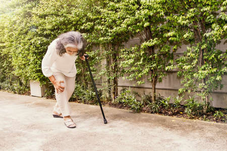 Senior asian woman aching knee with osteoarthritis during walking: Knee injury Inflammation is more common in the elderly 60 years: Health care concept : Selective Focus.の写真素材