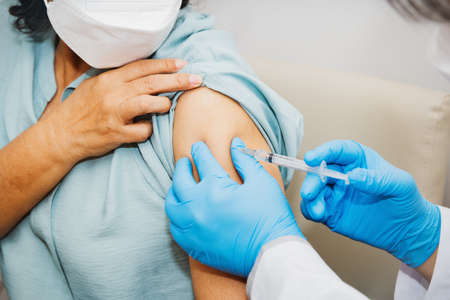 Doctor vaccinated mRNA against virus on the arm of an elderly woman to build immunity in the hospital : Concept of vaccination and preventing influenza or virus outbreakの写真素材