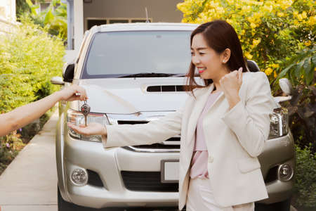 Business woman happily received the car keys after completing a successful financial transaction such as Insurance or car loanの写真素材