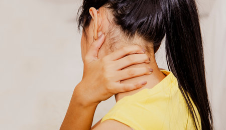 Back view Women have neck pain, deterioration of the neck, stiff neck from abnormal movements.causing nerve pain Or the spinal cord is used to massage the hands to relieve pain.の写真素材