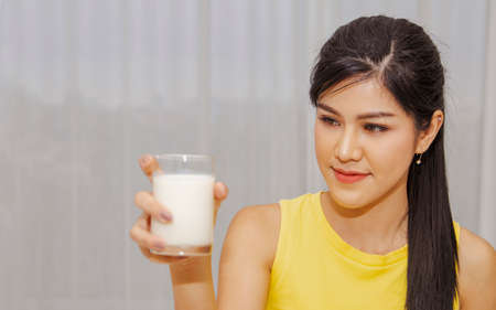 Young women drink healthy milk at night : Portrait beautiful asian women take care of their health by drinking fresh milk before bed to help them grow and stay healthy.の写真素材