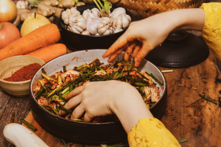 Top view motion blur hands of Asian women cook kimchi, using their hands to mix a traditional recipe with radish, chili and salt.の写真素材