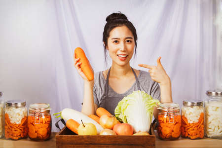 Portrait asian woman preparing carrots, fresh vegetables and fresh ingredients of good quality. Cook Traditional Korean Kimchi Recipe  The pride of a beautiful woman who makes kimchi to eat.の写真素材