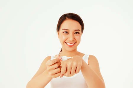 Portrait Asian young women use sunscreen lotion, applied on the back of the hand to preserve the skin and prevent UV light isolated on white.の写真素材