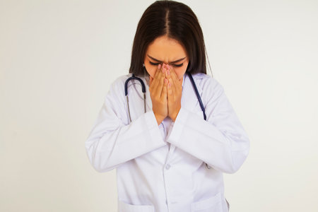 Female doctor sick with colds and allergies : Beautiful female doctor has symptoms of fatigue and discomfort due to a cold or bronchitis : health care conceptの写真素材