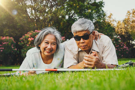 Head shot portrait happy senior couple, a husband who is blind but whose mind is bright and carefree because there is a cheerful wife and wife who are always loving and caring by their side.の写真素材