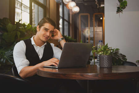 Business men sit in a cozy caf with a laptop computer. Work anywhere while waiting for a business meeting via video calling, video meeting plansの写真素材