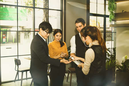 Group of business people join hands to keep their hands clean by using alcohol-based hand sanitiser...