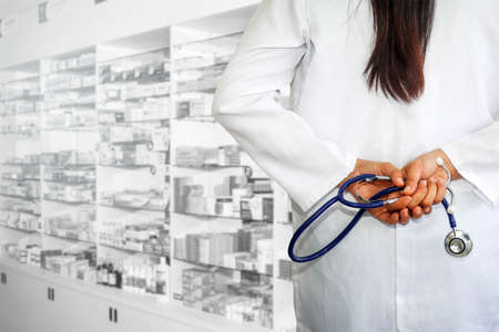 Behind the doctor, female, carrying a medical headset, working within the hospital dispensing room.の写真素材