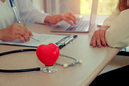Patient Care Concept : Female doctor diagnoses and records symptoms of female patients when they are hospitalized : Female doctor pays attention to the treatment when the patient comes to the hospitalの写真素材