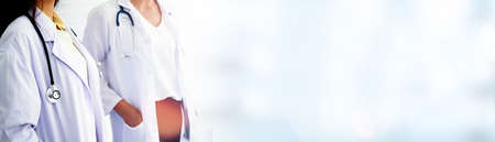 Two professional senior female medical teams in white medical uniforms and stethoscope stand health care services : Healthcare and medical or health insurance concept : Panoramic bannerの写真素材