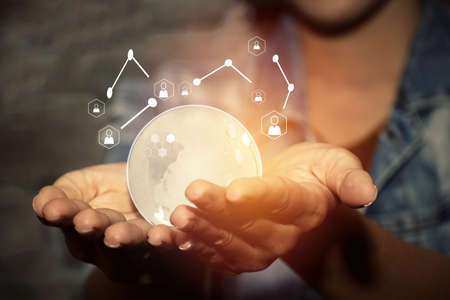 Young woman holding a crystal globe and using modern networks in the online world : Online communications and connectivity concept.の写真素材