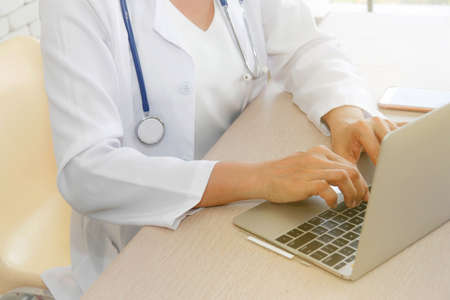 Doctors concept and medical technology : Close up on hands. Asian female Doctor working in hospital, examining patient history online : Selective Focusの写真素材