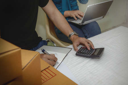 Young couple, business men and women sit and work and calculate income and expenses. Shares...