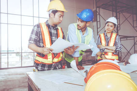 Photo blur, field engineer team : Consultation, work out the opinion of the planning of the construction of two male workers with a female engineer to listen to and stand in control nearby.の写真素材