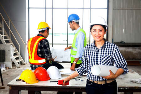 Leadership Concept by Female Engineers : Portrait of a happy female engineer in front of a group of...