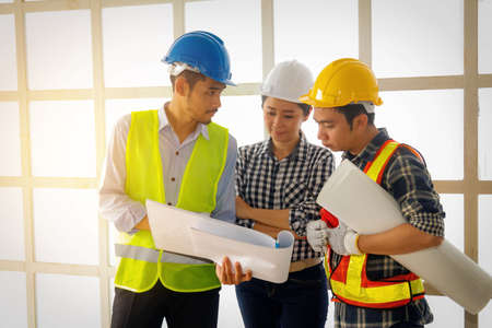Teamwork, and field operations of the engineering group, leading talented female architects  explaining with the male workers attentively.の写真素材
