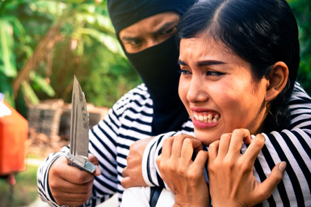 Crime concept : Young asian woman panicked and cried when a masked bandit was hijacked by a knife...