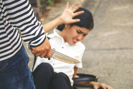 Crime concept : The villain uses a knife to intimidate a woman for a crime and all the way down to protect yourself.の写真素材