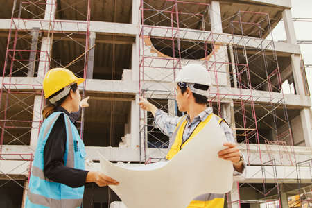 Architect and engineer discussing on blueprint at construction site. Civil engineering and architecture concept.の写真素材