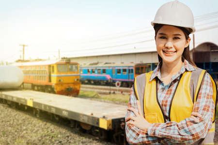 Portrait of a female worker standing with her arms crossed in front of a trainの写真素材