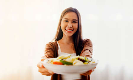 Charming women are skilled in cooking : Beautiful smiling asian woman shows off her culinary skills...