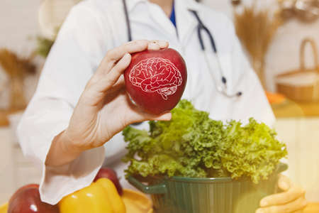 Female nutritionist doctor shows red apple fruit has brain nourishing benefits, inhibits Parkinson's disease, increases and nutritional health benefits : Health care and nutritionの写真素材