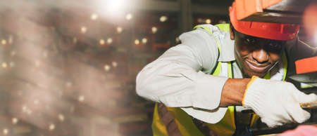 Portrait professional black male  safety helmet engineer african american shift worker specializing in metalworking machinery maintenance to efficiently engineer large industrial bの写真素材