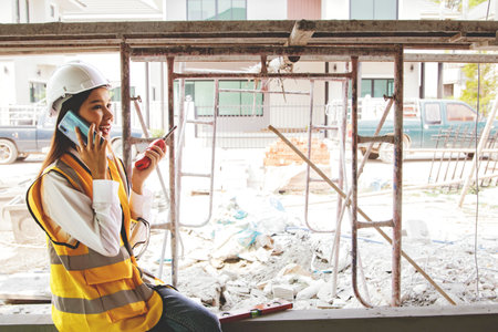 Female architect foreman oversees the construction talks on smartphones and radios reports...