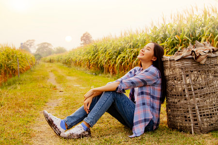 Asian female tourists sit back and relax enjoy life in the large corn fields in the cool summer sun : Conservation tourism conceptの写真素材