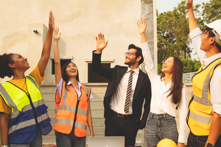 Senior male architects and diverse ethnic teams of men and women work together as a meeting team to show their cheers bravo! for the success of housing project construction.の写真素材