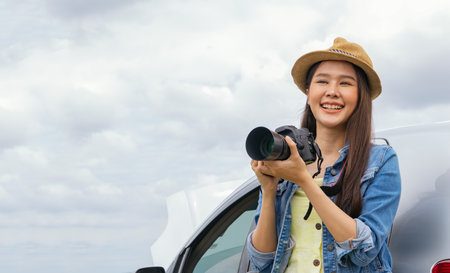 Female tourist an amateur photographer, travels by car, takes break and takes pictures of interesting attractions with fun and enjoyment : Good looking asian woman in modern dressの写真素材