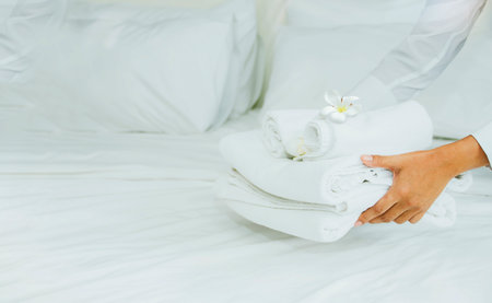 Female staff, housekeepers of hotels or resorts with services and facilities lay clean white towels to prepare customers for the best restful stay.の写真素材