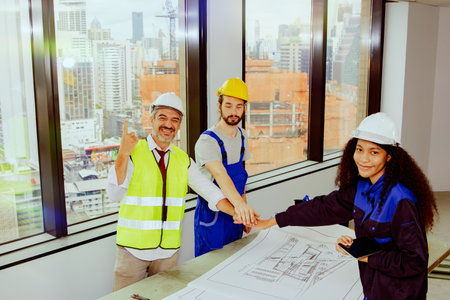 Team of senior architects and female architect assistants and male workers work together to collaborate on the construction of a new office renovation project in a high rise buildiの写真素材