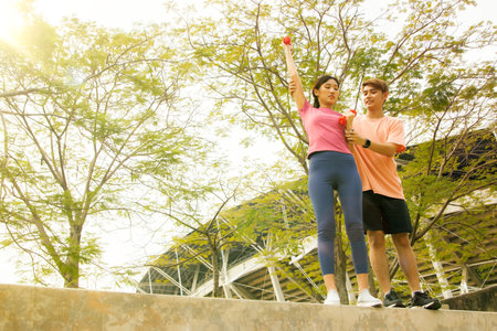 Young couple doing stretching exercise in the park. Healthy lifestyle concept.の写真素材