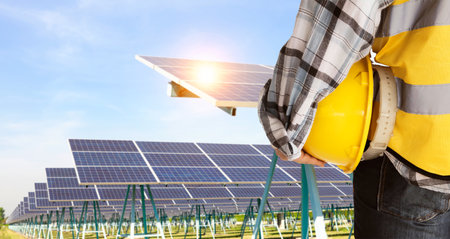 engineer with safety helmet and solar panel in solar power plant backgroundの写真素材