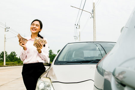 Happy carefree smile asian businesswoman financial ready cash showing budget have credit when car accident : Accident and car insurance concept.の写真素材