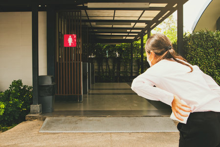 Sick woman walking stooped severe abdominal pain gastrointestinal system problems, nausea, vomiting, diarrhea, constipation, holding tissue, rushing to a public toilet during the tの写真素材
