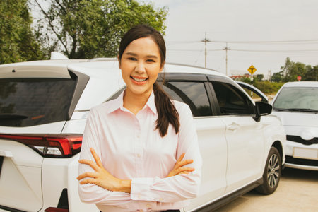Asian female drivers stand smile reassuringly when having car insurance that protects against road accidents while traveling because Prasammitr Motor Insurance takes care of it : Cの写真素材