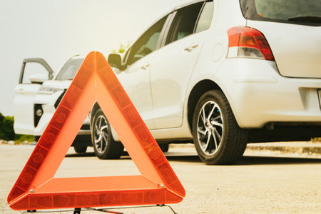 Closeup of red reflective triangle warning symbol sign signaling danger : Road accidents driving illegally personal cars colliding and colliding with damage : Car insurance compensの写真素材