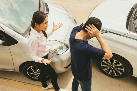 Angry woman quarrels with man who drives car in front of him suddenly causing an accident on the road that drives private car illegally causing damage, requiring insurance liabilitの写真素材